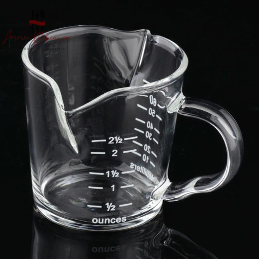 Dual spout clear glass espresso measuring cup with handle showing ounce and milliliter markings