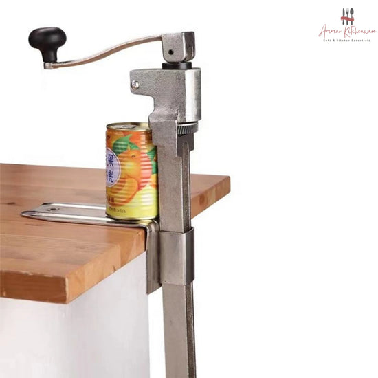 Commercial cast steel manual can opener featuring a table-mounted base plate and ergonomic turning handle.