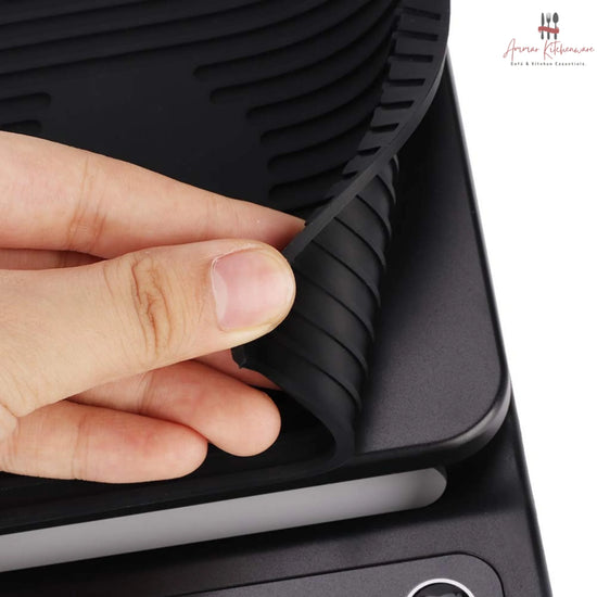 Black digital coffee scale with green dual backlit screen, integrated timer, and removable black silicone mat
