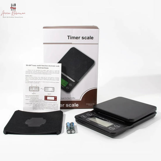 Black digital coffee scale with green dual backlit screen, integrated timer, and removable black silicone mat