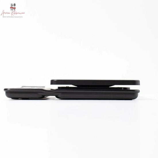 Black digital coffee scale with green dual backlit screen, integrated timer, and removable black silicone mat