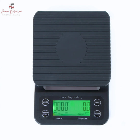 Black digital coffee scale with green dual backlit screen, integrated timer, and removable black silicone mat