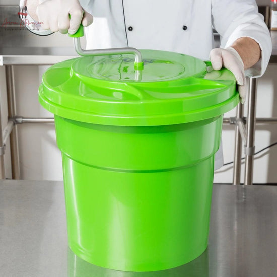Commercial green salad spinner with metal hand crank arm and white inner colander basket
